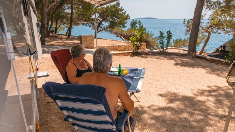 Ein Paar entspannt in Campingstühlen am Meer